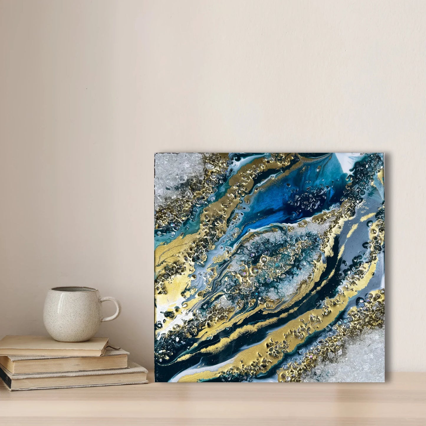 Modernes Geode Wandbild als Wohndeko im Wohnzimmer auf einer Kommode neben Büchern