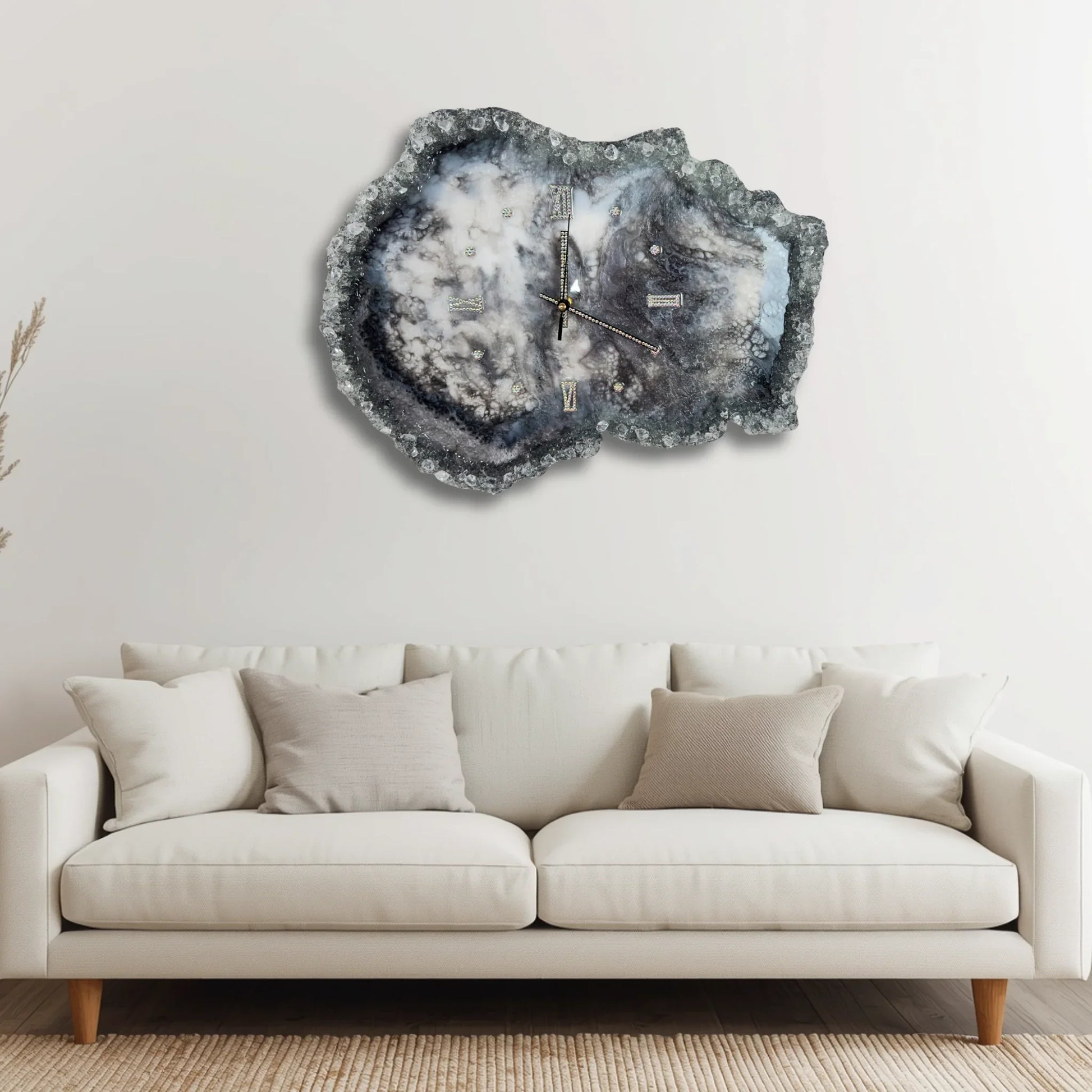 Moderne Geoden-Wanduhr aus Epoxidharz als stilvolles Dekorelement über einem weißen Sofa in einem hellen, minimalistischen Wohnzimmer.
