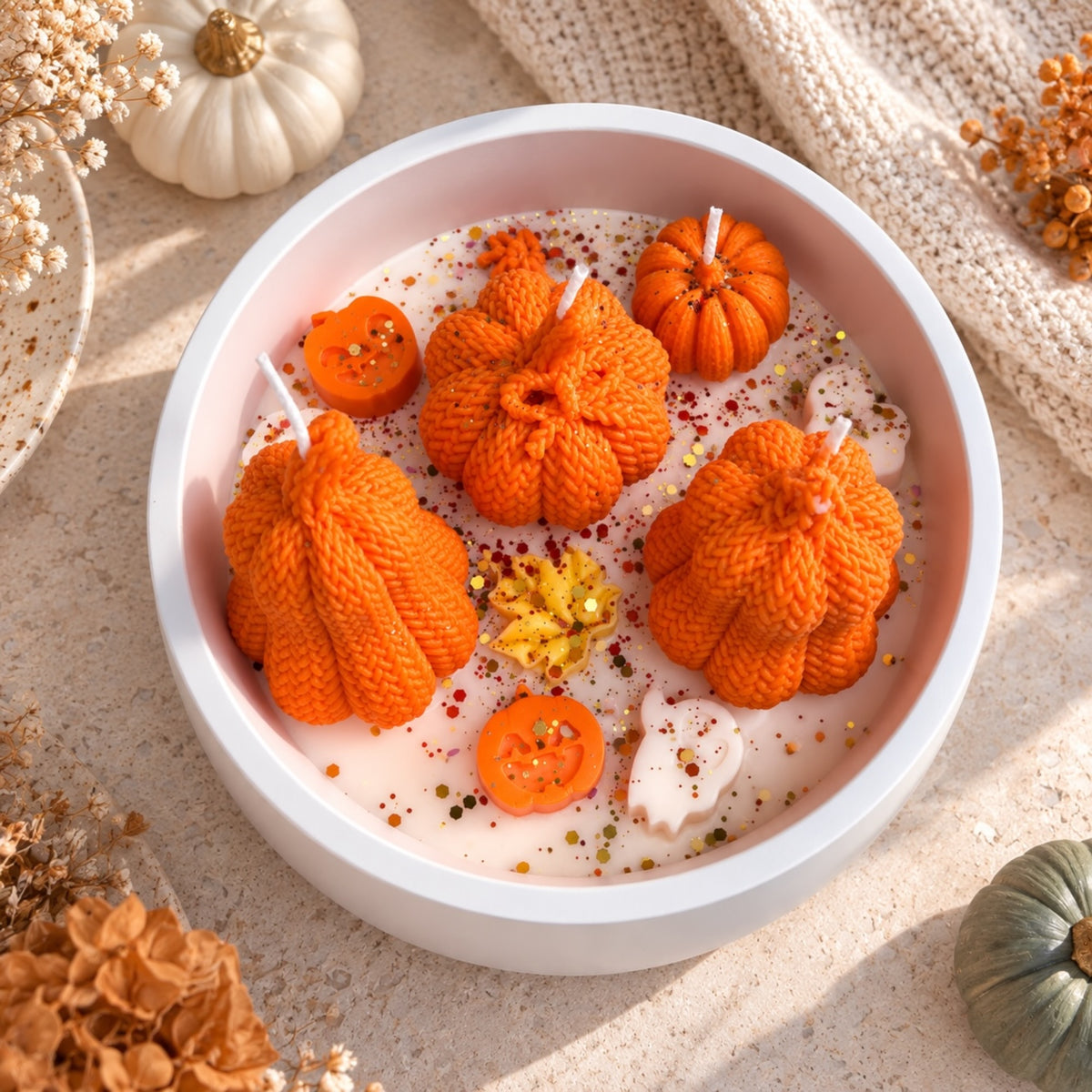 Kürbis-Duftkerze in runder Bowl von oben – orange Strickoptik-Kürbisse mit Herbstmotiven, Cozy Herbstdeko
