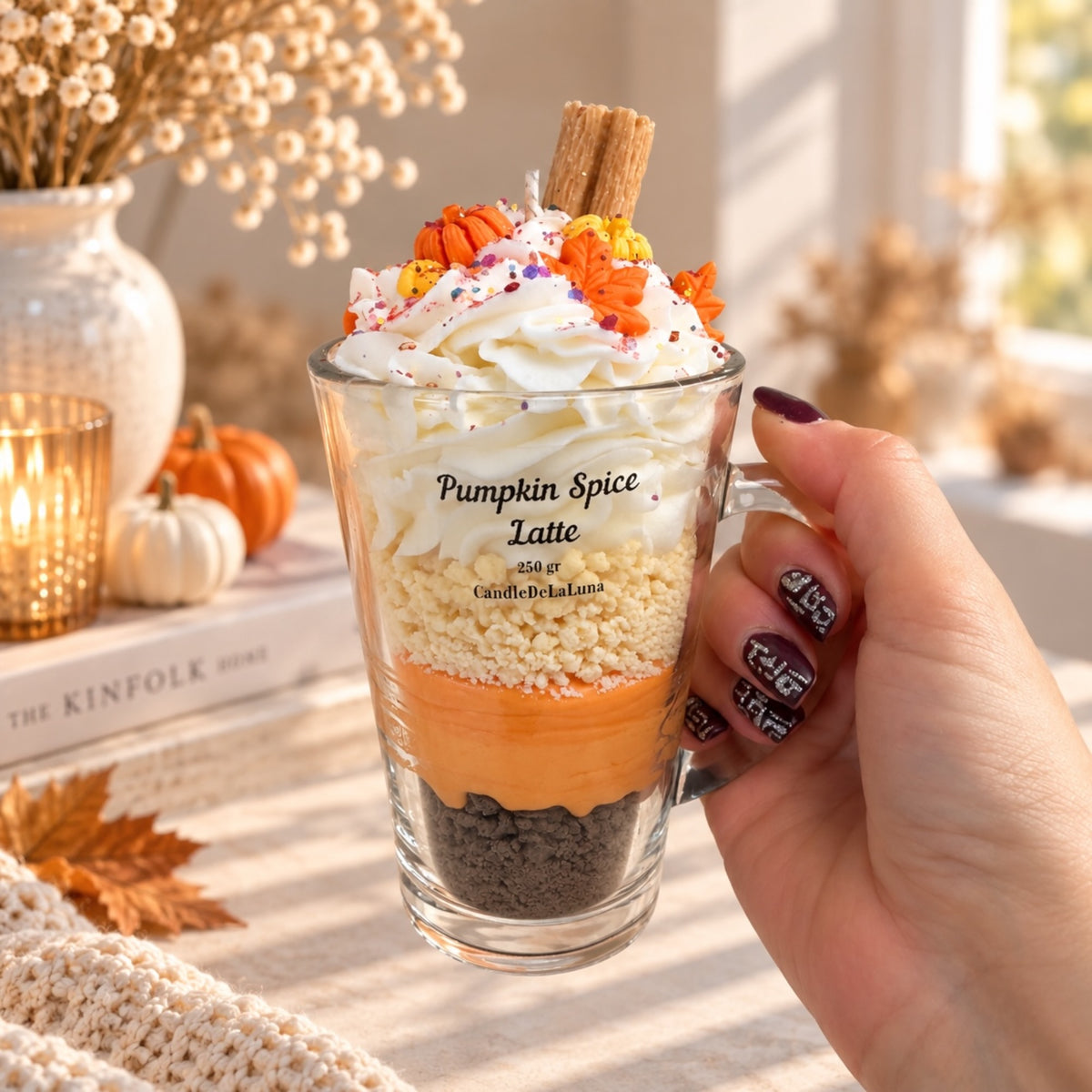 Pumpkin Spice Latte Dessertkerze in der Hand – Größenvergleich, Schichten aus Wachs mit Sahne, Kürbis-Details und Zimtstange, handgefertigte Duftkerze von DaarArt
