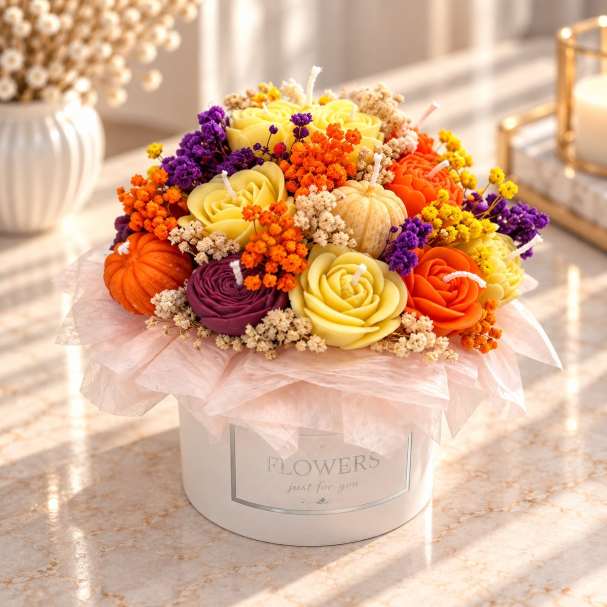 Kerzenbouquet in weißer Blumenbox mit Rosen, Kürbissen und Trockenblumen in Orange, Gelb und Bordeaux
