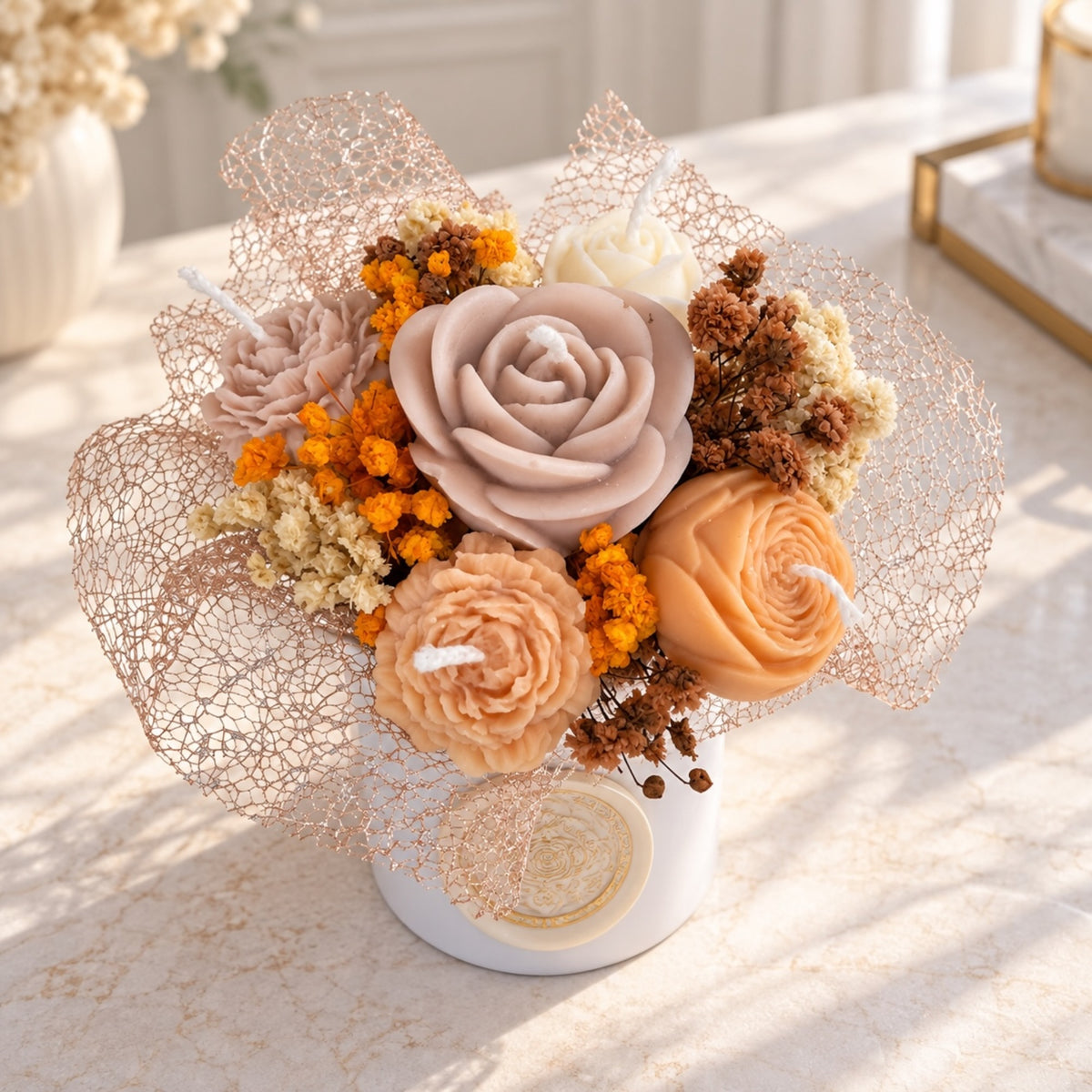 Kerzenstrauß mit altrosa Rosenkerze, Pfingstrosen in Pfirsich und Trockenblumen in Orange und Braun
