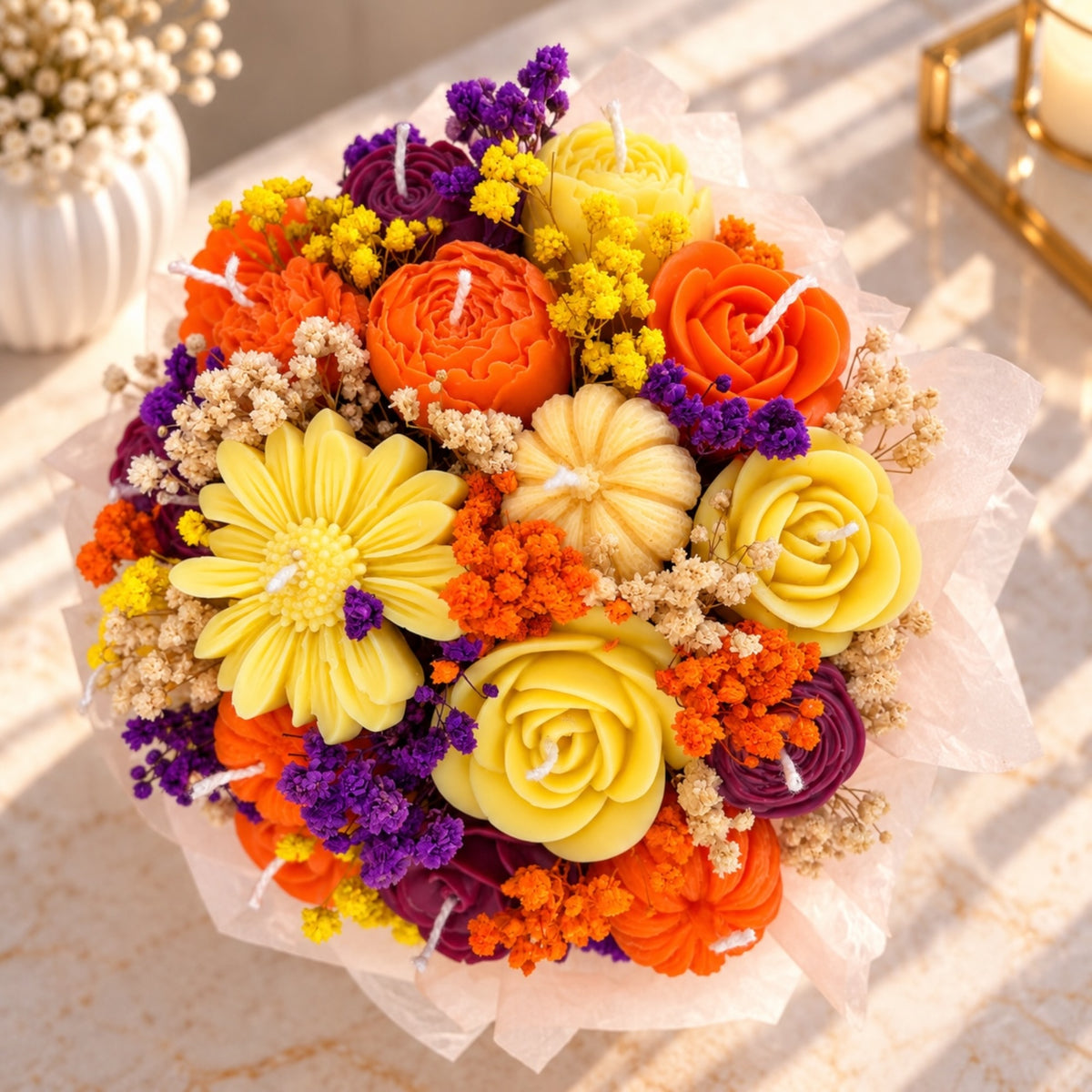 Draufsicht auf das Kerzenbouquet mit Wachsrosen, Margerite, Kürbissen und Schleierkraut
