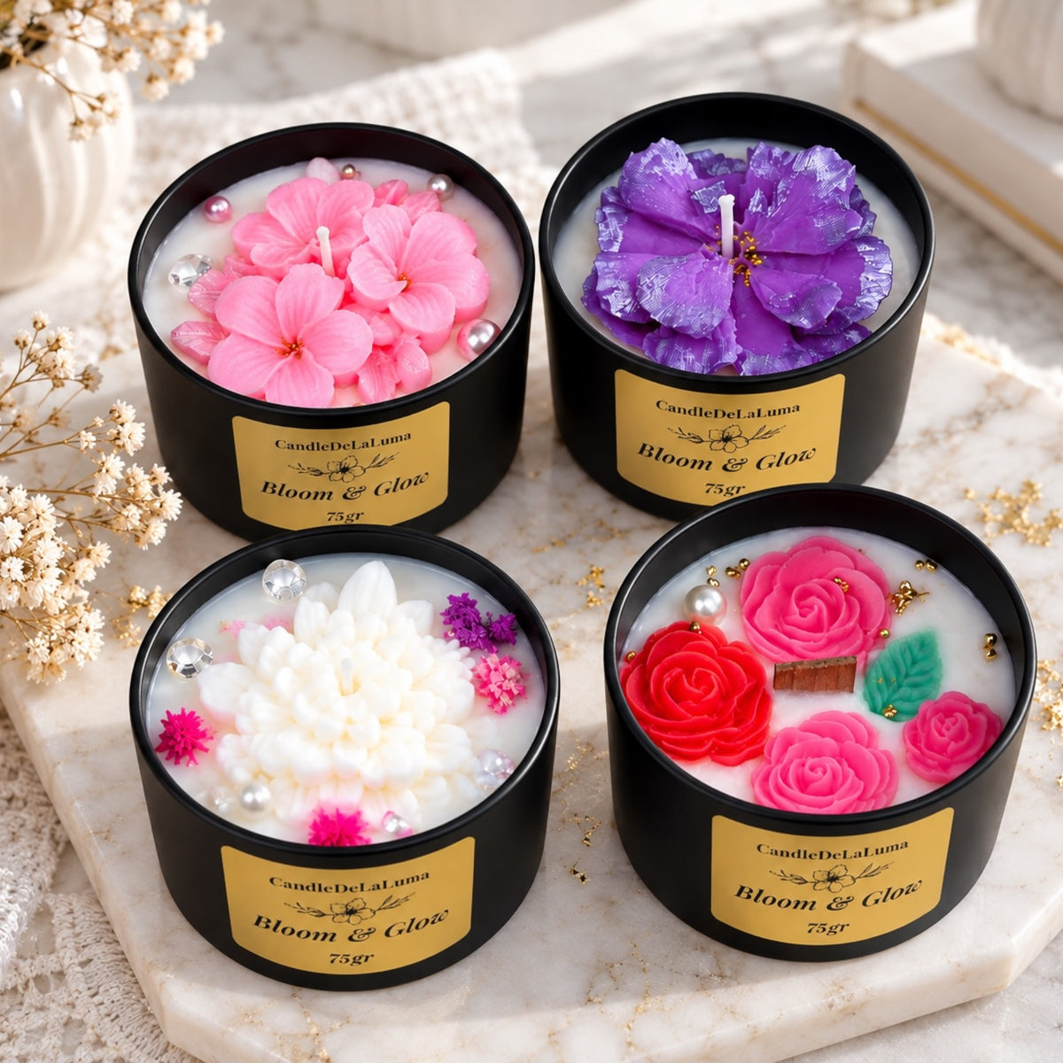 Vier botanische Kerzen in schwarzen Dosen mit rosa, violetten, weißen und roten Blütenmotiven
