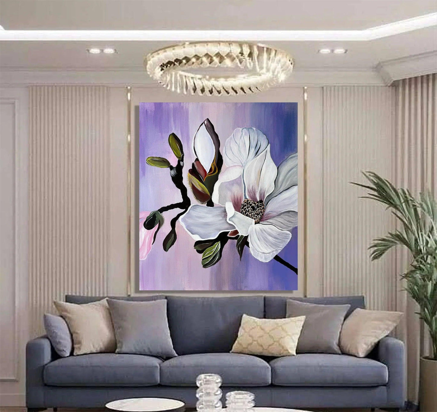 Modernes handgemaltes Magnolien-Wandbild in Violett und Weiß über einem blauen Sofa, florale Leinwandkunst in einem stilvollen Wohnzimmer mit modernen Wandpaneelen.
