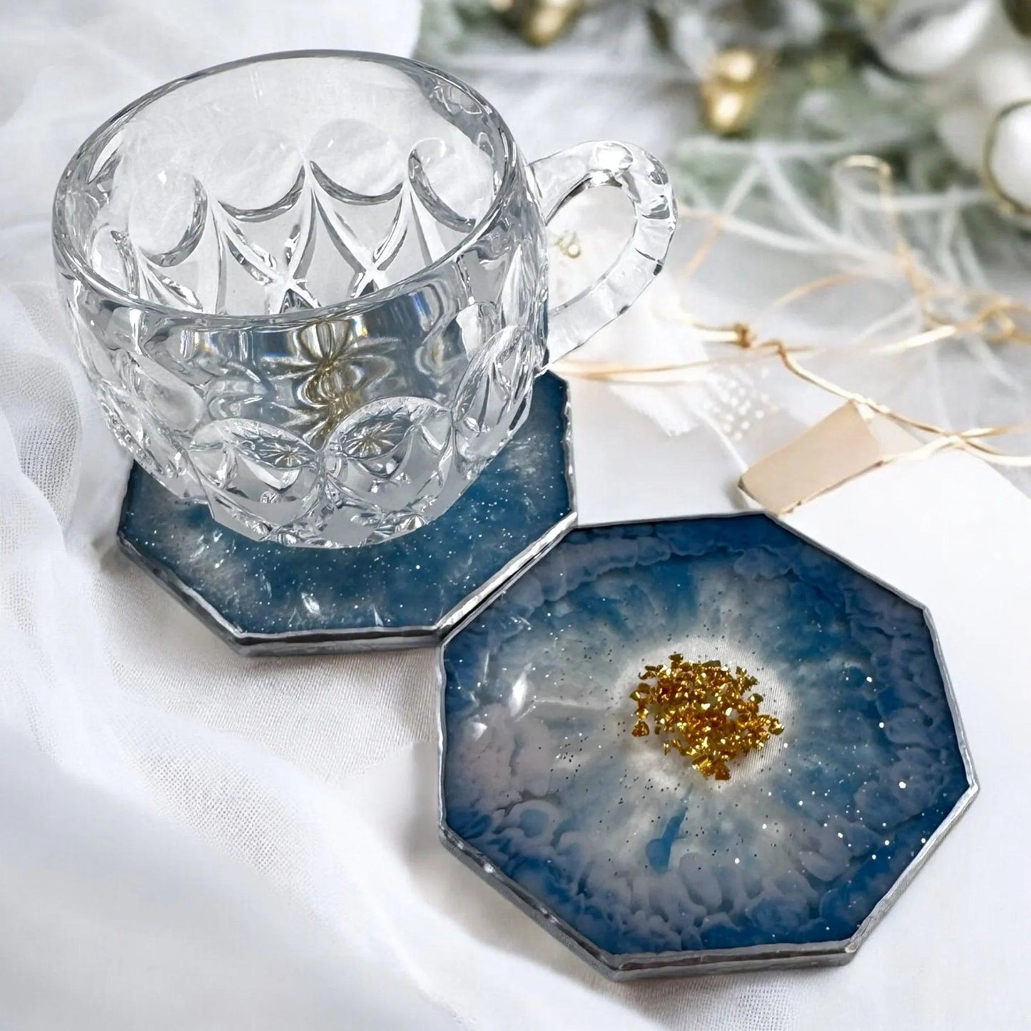Serviervorschlag für handgefertigte Untersetzer: Gläseruntersetzer in Blau-Silber Optik mit einer Teetasse
