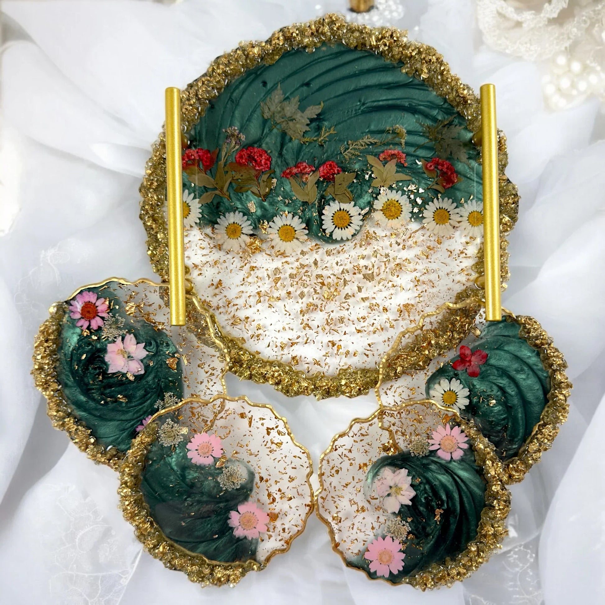 Kombinationsset aus einem runden Serviertablett mit goldenen Griffen und vier passenden Untersetzern aus Resin in Smaragdgrün mit echten Blumen.
