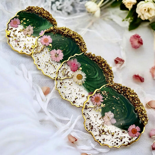 Untersetzer 4er Set aus Epoxidharz in Grün und Weiß mit echten rosa Blumen, Blattgold und goldenem Rand aus Bergkristallen.