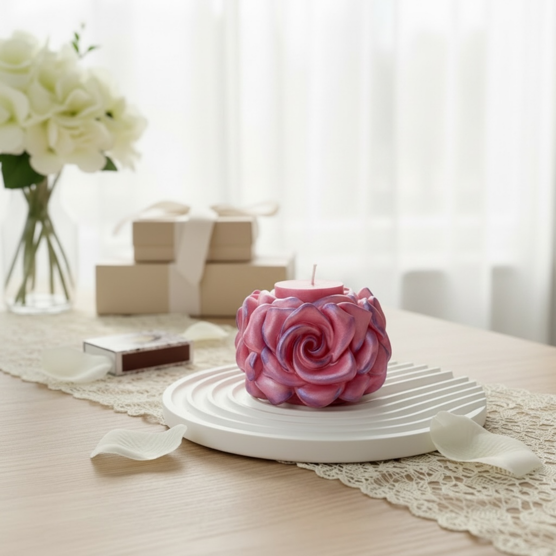 Eine schimmernde rosa Rosenkerze auf einem weißen runden Dekotablett, platziert auf einem festlich gedeckten Tisch mit Geschenken und Blumen im Hintergrund.
