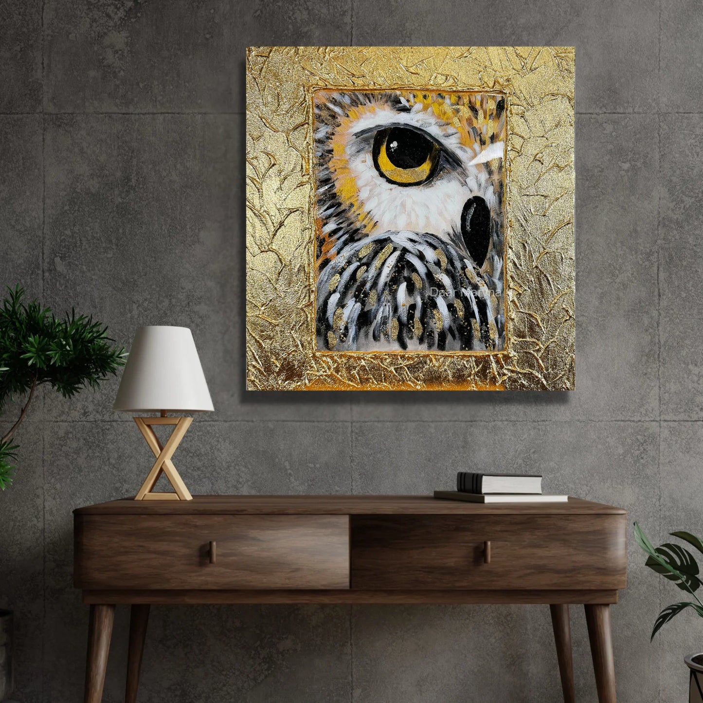 Goldenes Eulen-Wandbild auf einer grauen Betonwand über einer Holzkonsole, moderner Kontrast zwischen Gold-Struktur und Loft-Interieur.