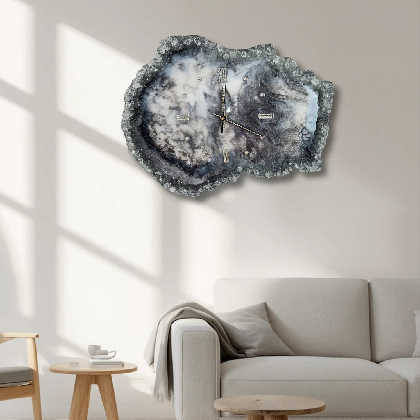 Große, dekorative Geoden-Wanduhr aus Epoxidharz als Blickfang an einer hellen Wand im modernen Wohnzimmer über einem grauen Sofa.