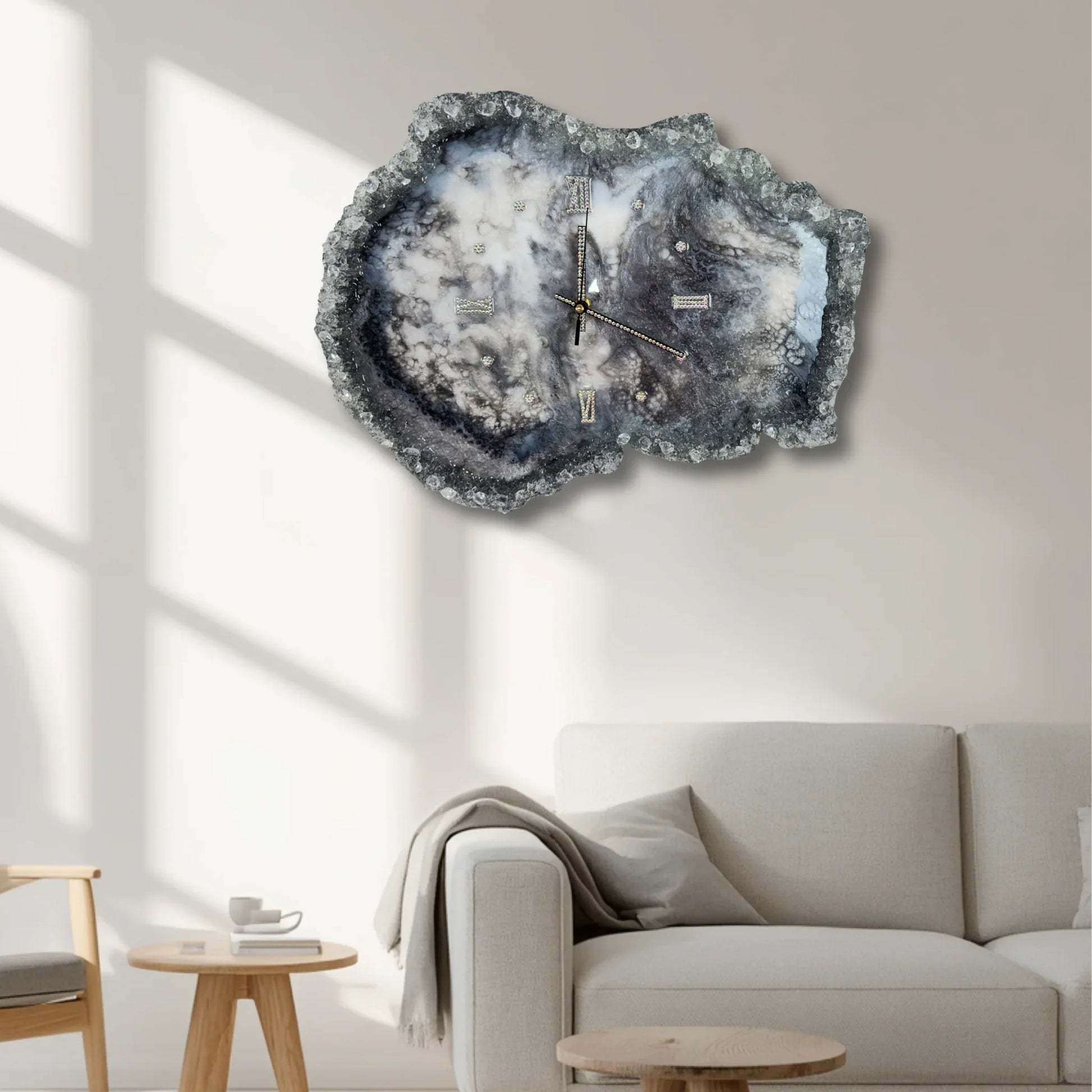 Große, dekorative Geoden-Wanduhr aus Epoxidharz als Blickfang an einer hellen Wand im modernen Wohnzimmer über einem grauen Sofa.
